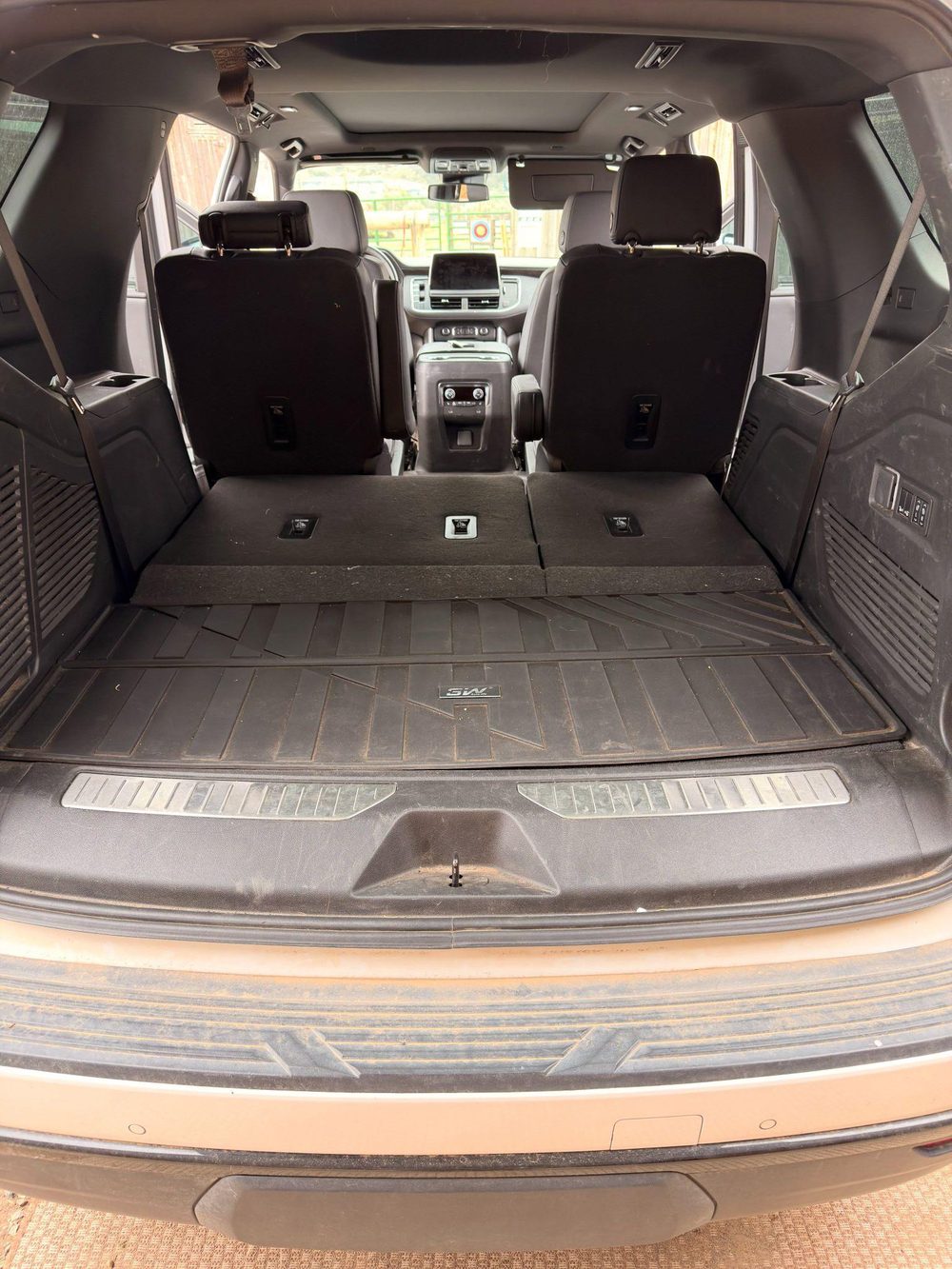 SUV cargo area before detailing — dusty and dirty